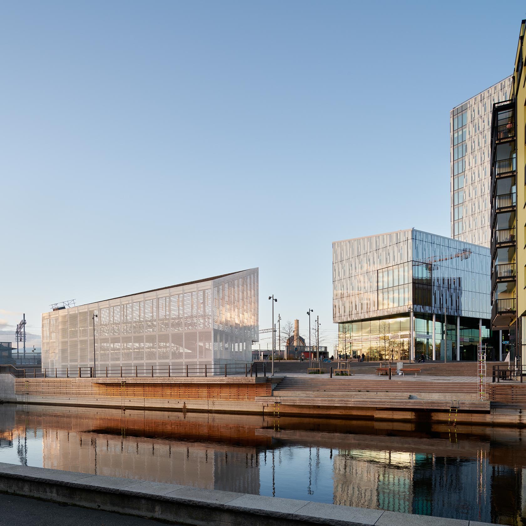 Ljusa byggnader vid Gamlestadens resecentrum, med trappor ner mot vattnet.